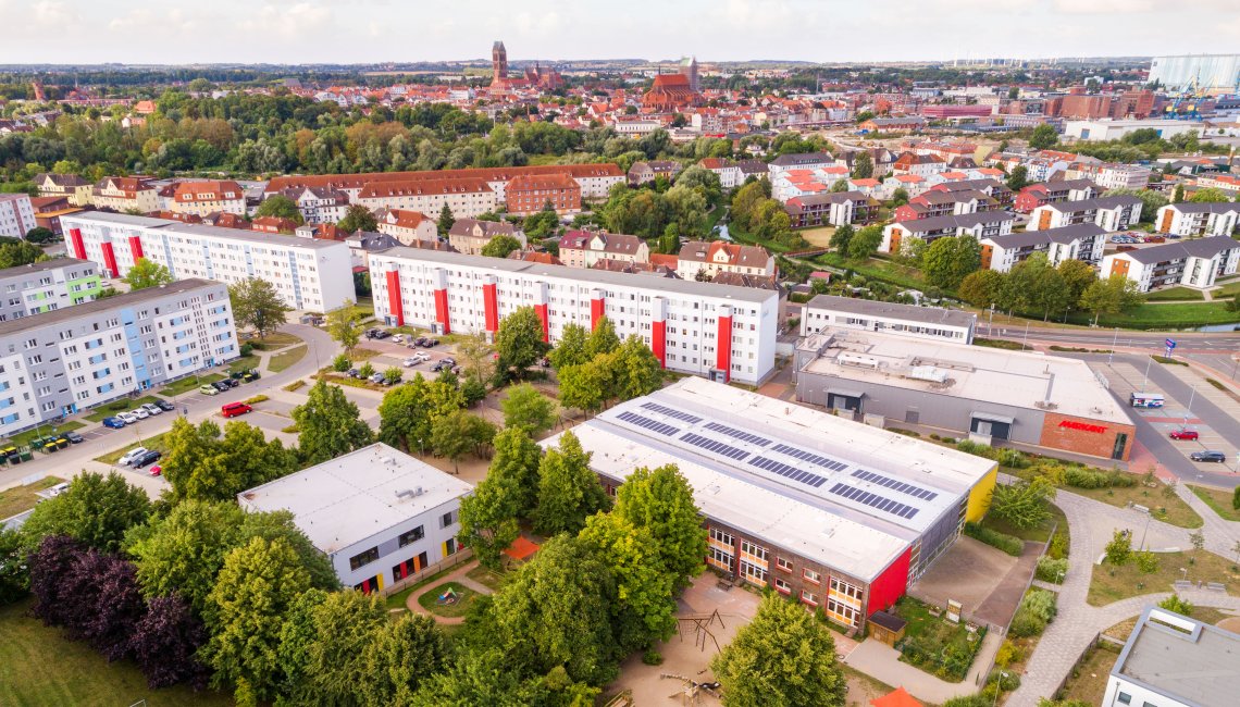 Eine Drohnenaufnahme der Kita Sonnenschein. Im Hintergrund ist Wismar zu sehen.